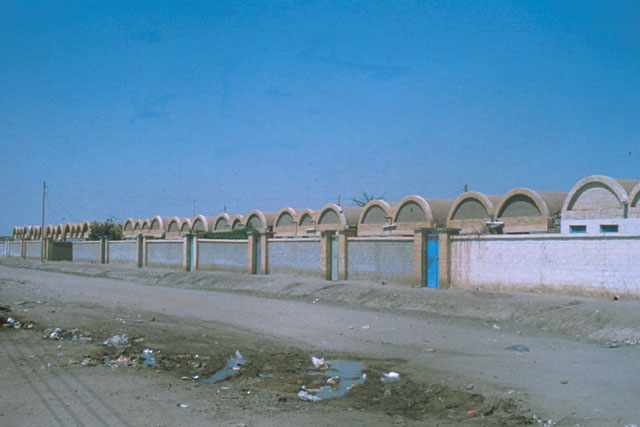Exterior view along protective wall showing modular vault roofs of housing