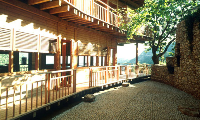 Exterior view showing common area between wooden structure and stone wall