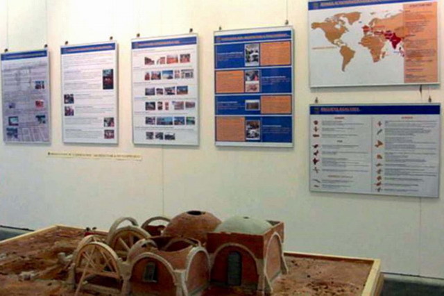 View of exhibition on housing program, with presentation panels and scale model showing construction details