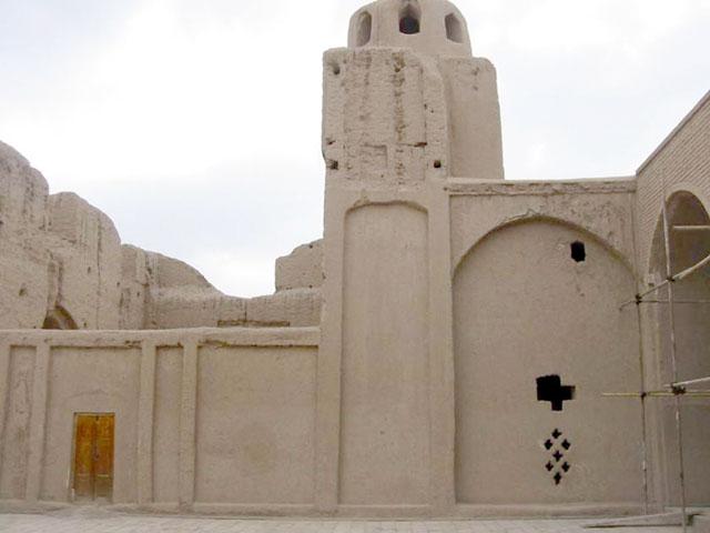 Exterior view from within the courtyard of mosque prior to the earthquake. Openings in a decorative pattern appear in the mud brick wall at the right-hand side of the frame