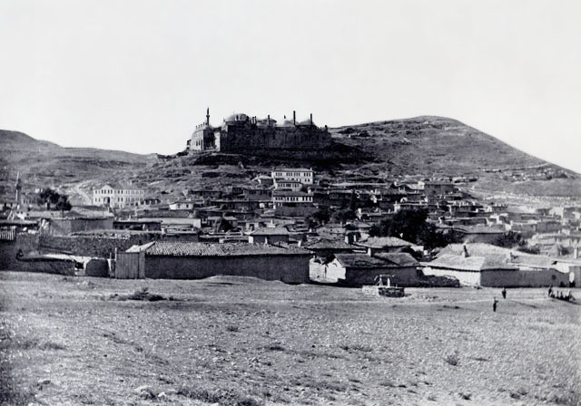Exterior view from  east showing convent on hill with village below