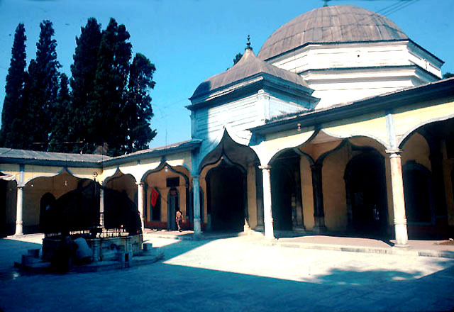 View of mausoleum from south, preceded by domed portal continuous with wooden gallery of courtyard