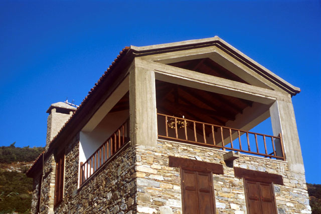 Exterior detail showing stone house with upper level balcony