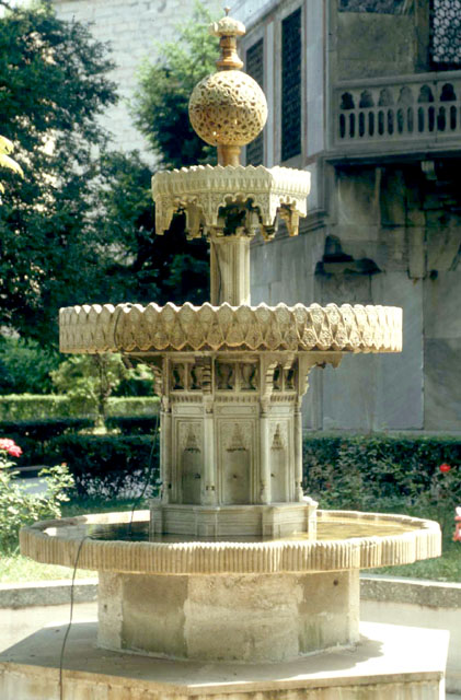 Baghdad Kiosk - Marble fountain in Ottoman baroque style, furnished with spouts to fill surrounding basin in upper gardens of the Fourth Court.  The Baghdad Kiosk (Bagdat Köskü) in seen the background