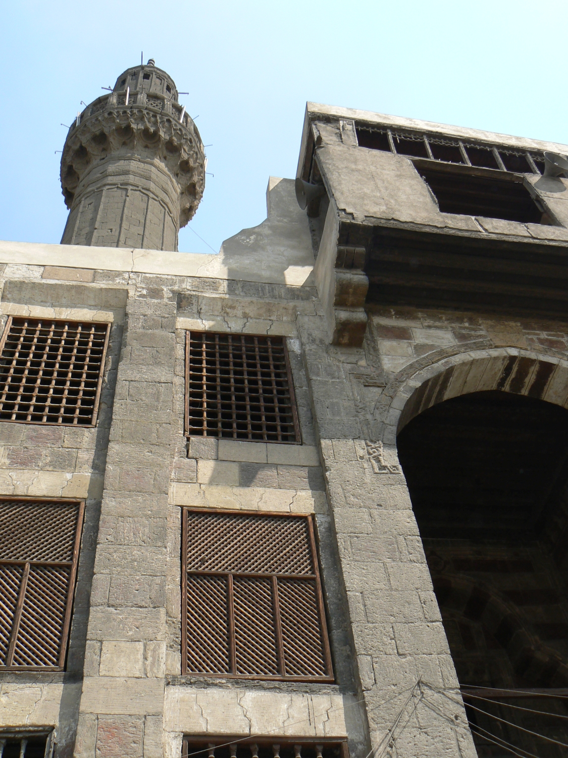 Upwards view of the front facade to the left of the main portal, with partial view of the minaret