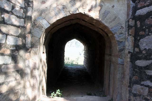 View of ogee arched passage in the lower level of the dam, flanked by stone buttresses on either side