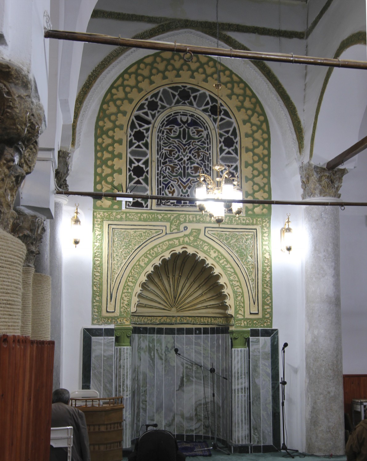 View of the mihrab niche fronted by a pointed arch, with fluted half-dome visible at the bottom