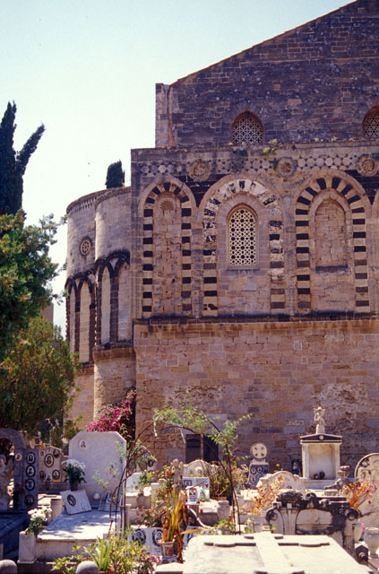 Exterior view of side elevation and apses, with tombs in foreground