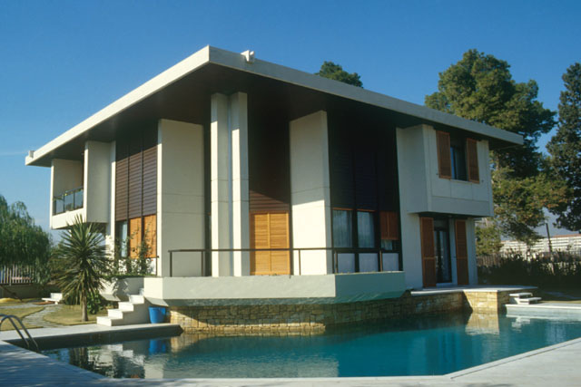 Exterior view showing stucco and wood façade and poolside