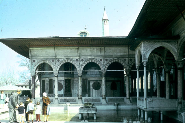 View of the Revan Kiosk from northwest with the pool of Süleyman I in the foreground.  To the right, the colonnade of the Pavilion of the Blessed Mantle, with the balcony of the sultan projecting over the pool