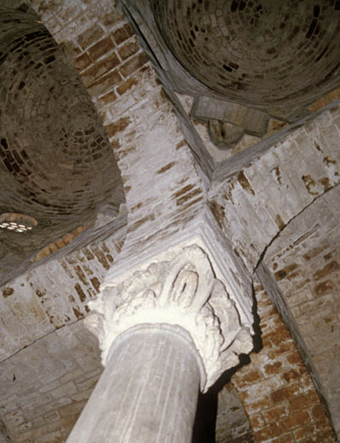 Interior detail; column and capital with acanthus leaves. Profile of muqarnas squinch of a nave dome appears above
