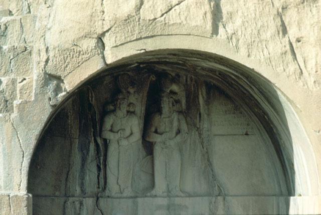 Shapur II and III Iwans: Detail view of the bas-relief carving in the right iwan  depicting the investiture of Shapur III