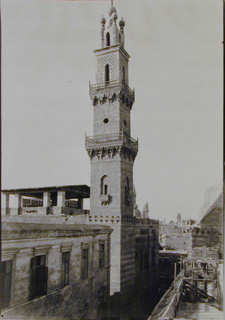 Elevated exterior view of mosque-madrasa, looking north down the east (al-Muizz Street) façade with minaret