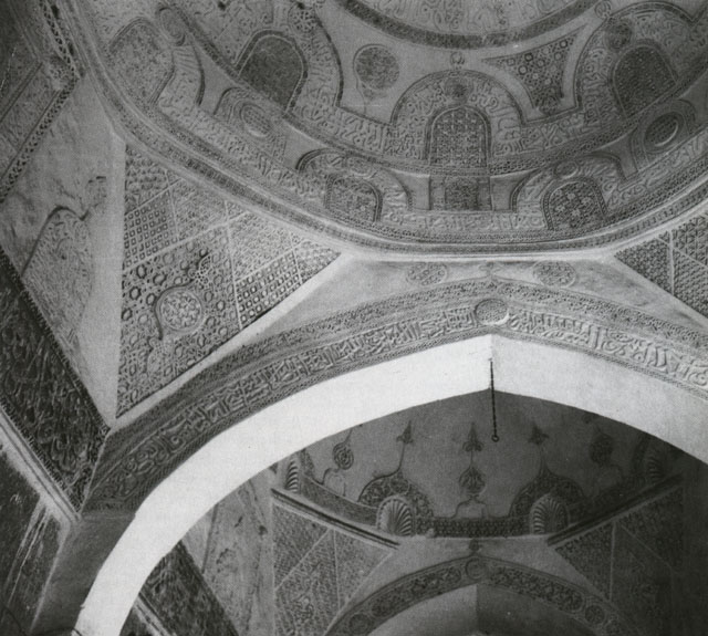 View looking up into the carved gypsum ornament and inscriptions of the portico