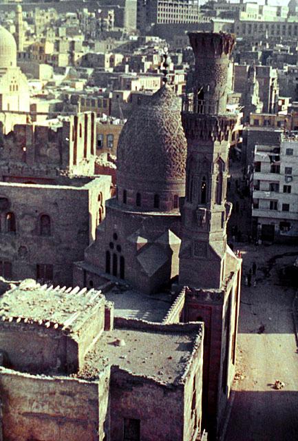 Elevated view showing the minaret and dome of the Khayrbak Complex and the palace remains, with the Citadel in the far background