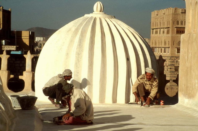 Roof terrace; polishing of <i>qudad</i>, a traditional waterproofing mortar. Ribbed dome of west gallery seen behind workers