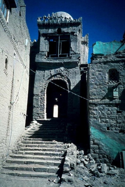 East porch, before restoration, with stairs abutted by residential structures (building to the left since removed)