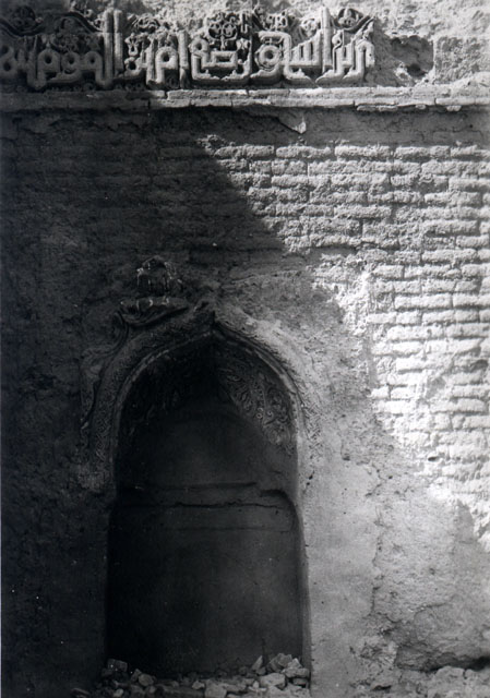 View of mihrab on west wall of northwest iwan with a segment of Kufic inscription above