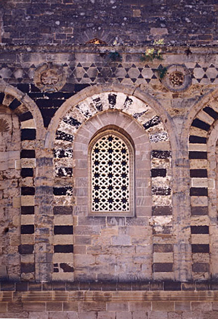 Exterior detail of side elevation; window with stone lattice framed with alternating black and white stones