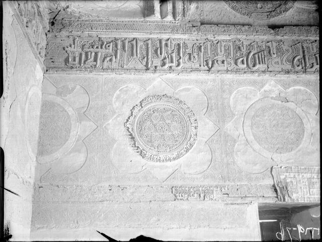 Interior, stucco decoration above the doorway with an inscription band