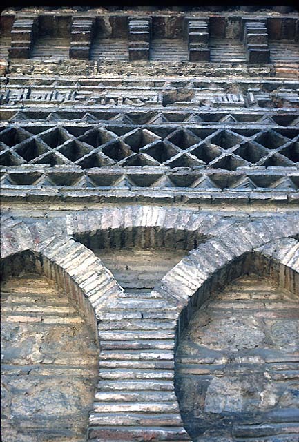 Mezquita del Cristo de la Luz - East façade detail. Intersecting arches, ornamental frieze and foundation inscription in brick