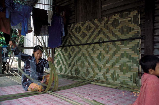 Village woman weaving reed panels