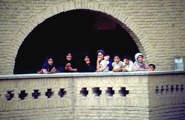 People on balcony, brick façade