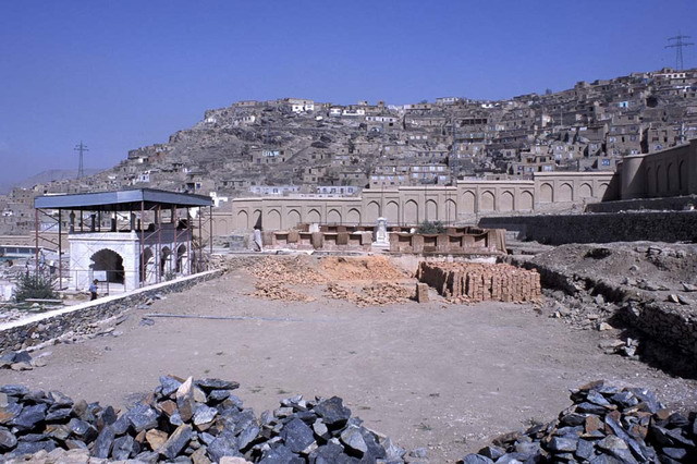 Construction of brick outer enclosure around Babur's grave, view looking northeast, prior to grading of tomb terrace. The Shahjahani Mosque is seen under restoration on the left