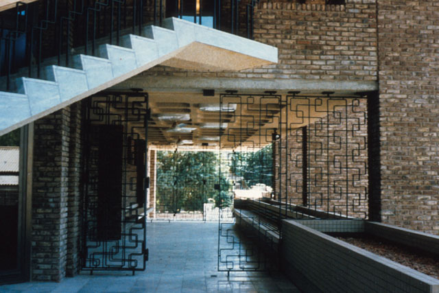 Interior detail showing concrete stairs with iron fence and brick walls
