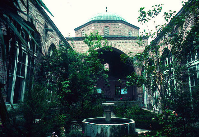 View of the courtyard of madrasa, looking towards the large domed classroom (dersane); the portico around courtyard has been glazed at restoration