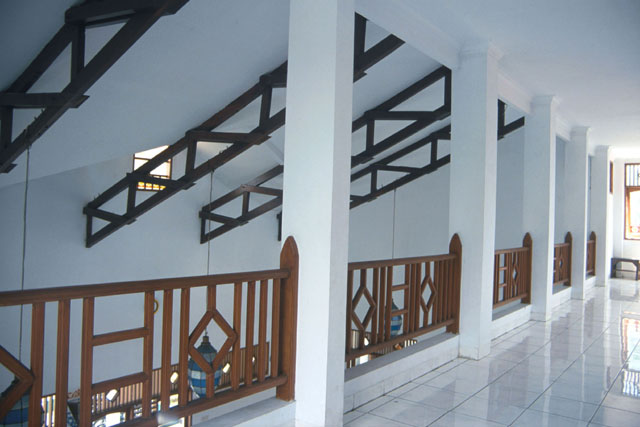 Interior view showing highly polished tile floors and decorative wooden beams on underside of pitched roof