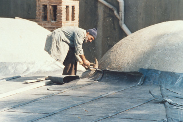 Exterior detail showing laborer laying the roof