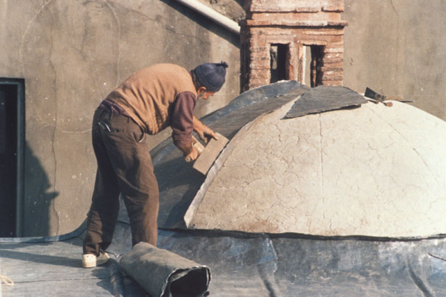 Exterior detail showing laborer laying the roof