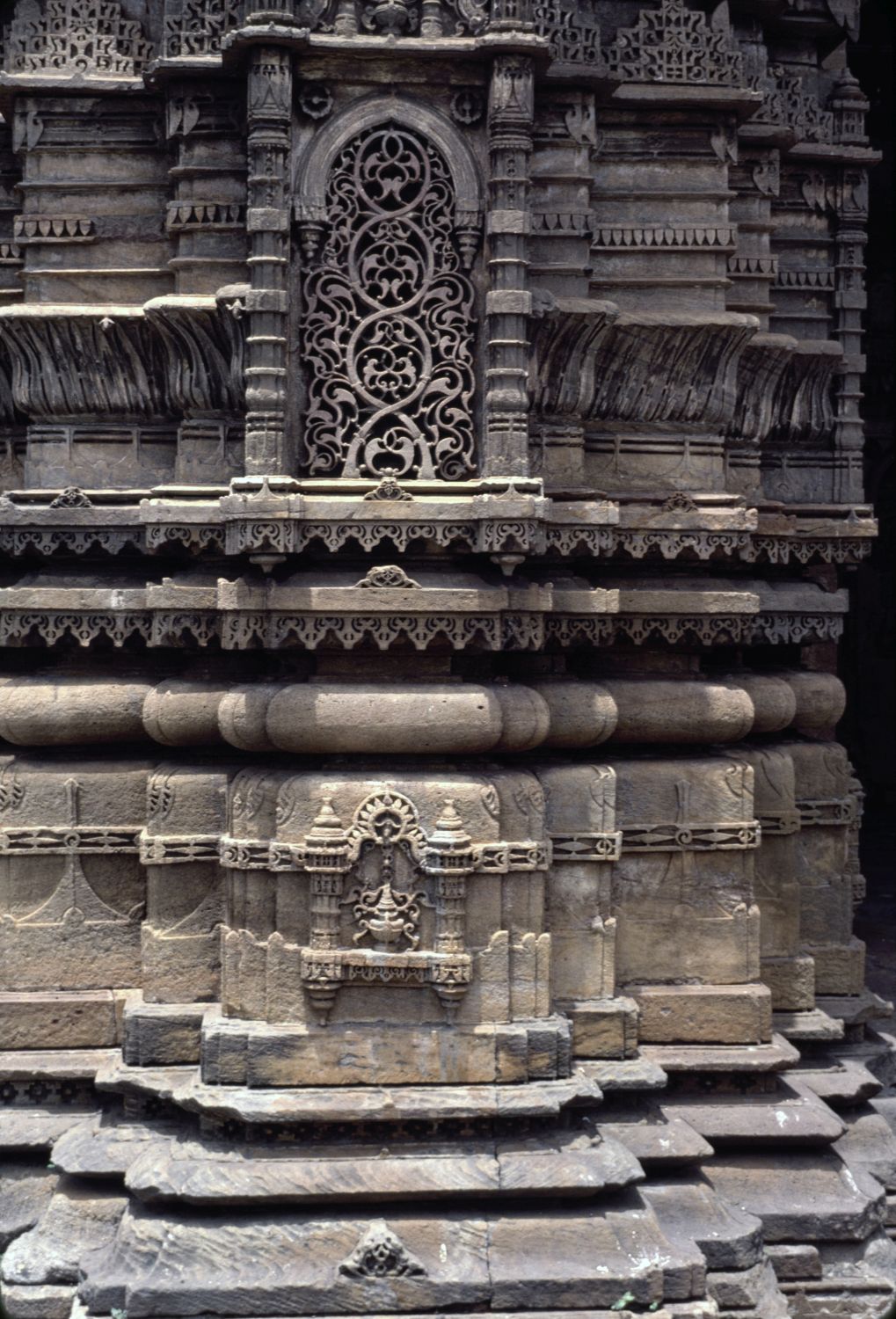 Detail view of minaret showing registers of carving and plaque with vine scroll motif.