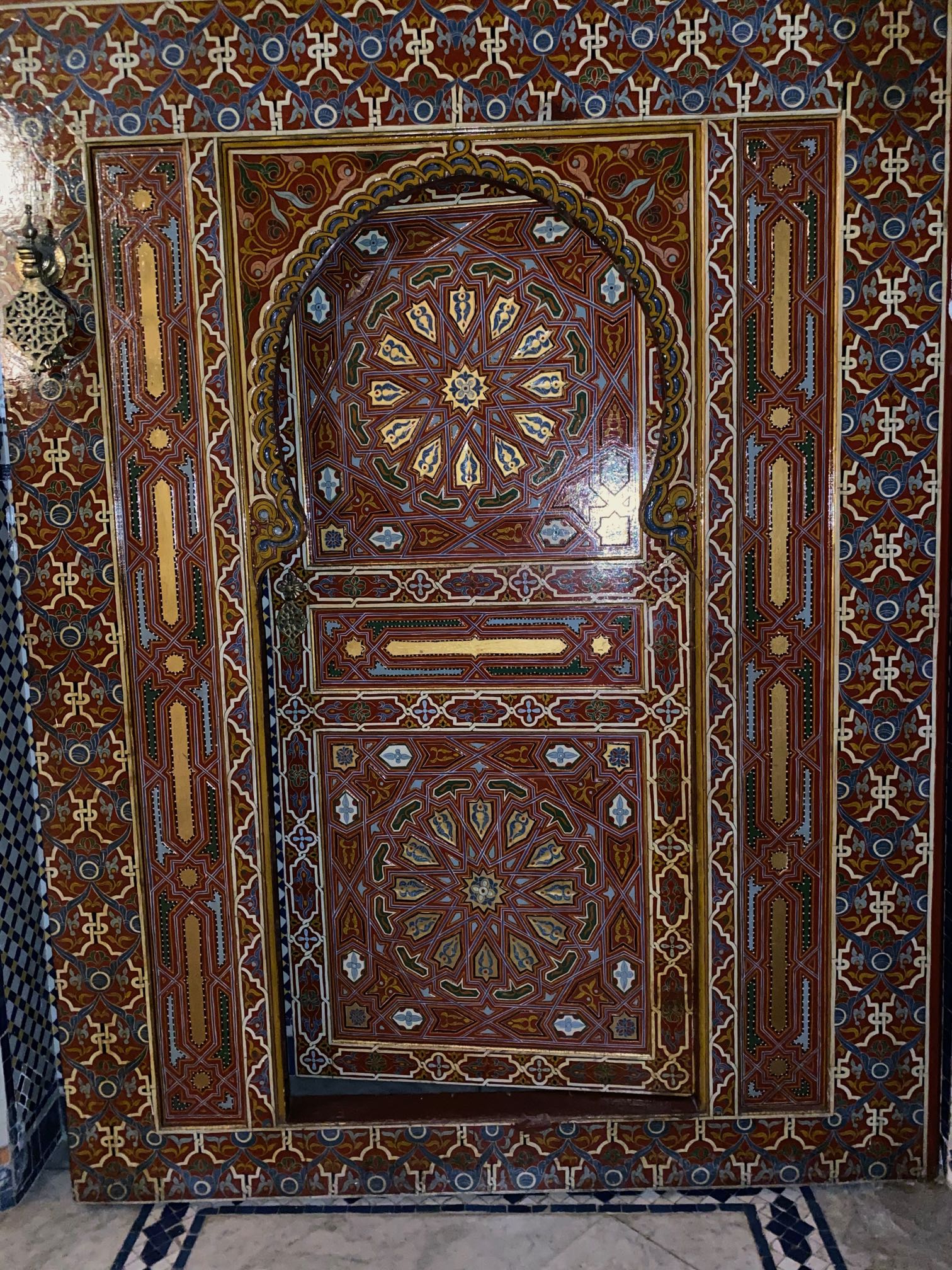 <p>Wooden door with elaborate geometric designs and floral motifs</p>