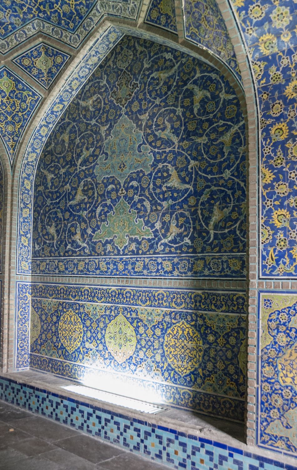 Corridor behind entrance portal, view of tile panel on side wall.