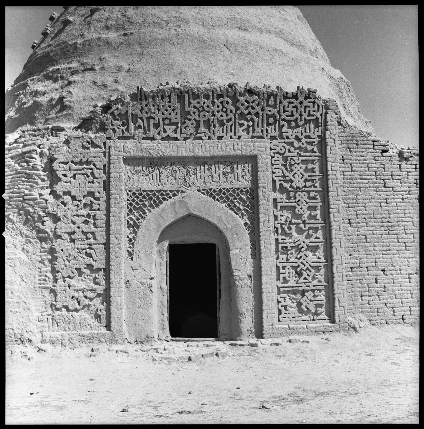 Exterior view from south showing arched doorway with Kufic inscription above.