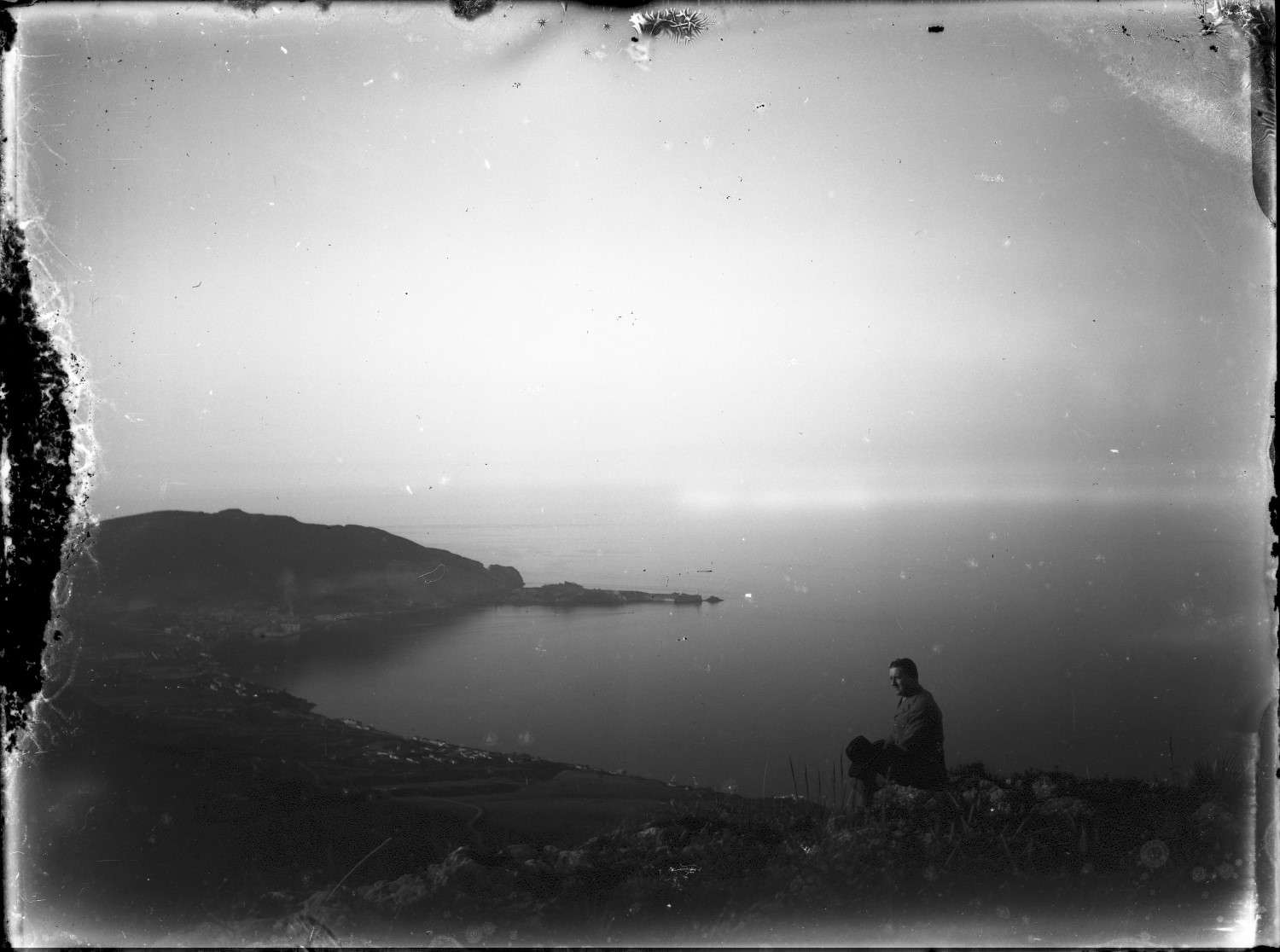 A seated figure near at Fort Saint Andre, with a view of Fort Santa Cruz from Mers el Kebir (the Great Harbor) .