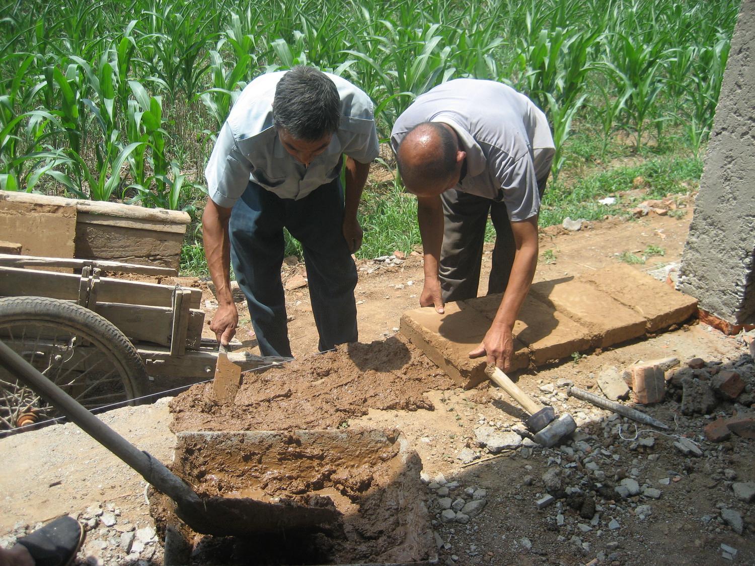 Workers laying the mud bricks
