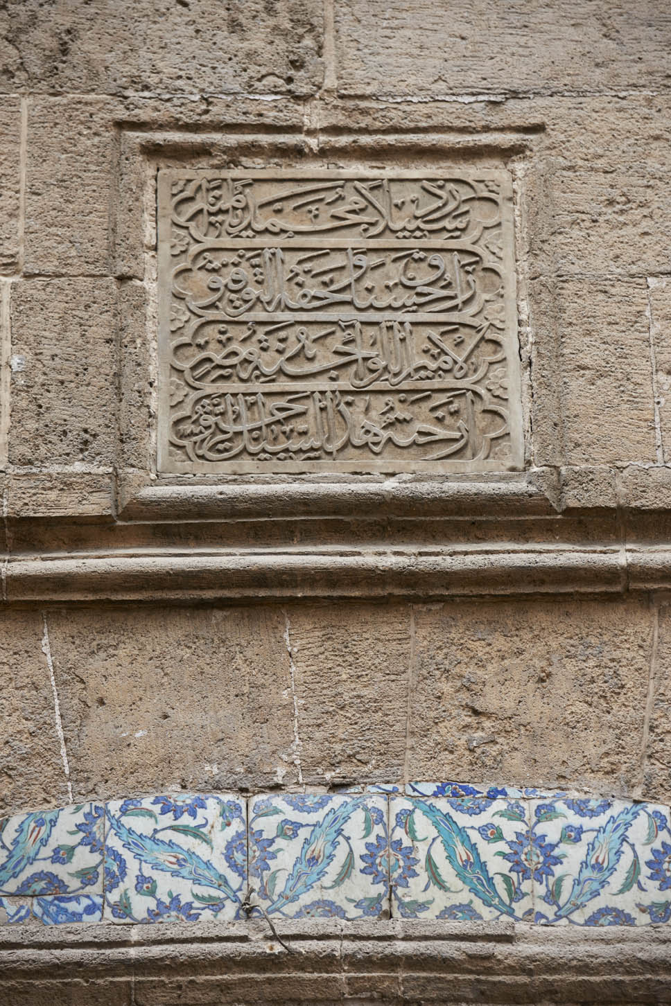 Exterior, detail of inscription panel above sabil grilles