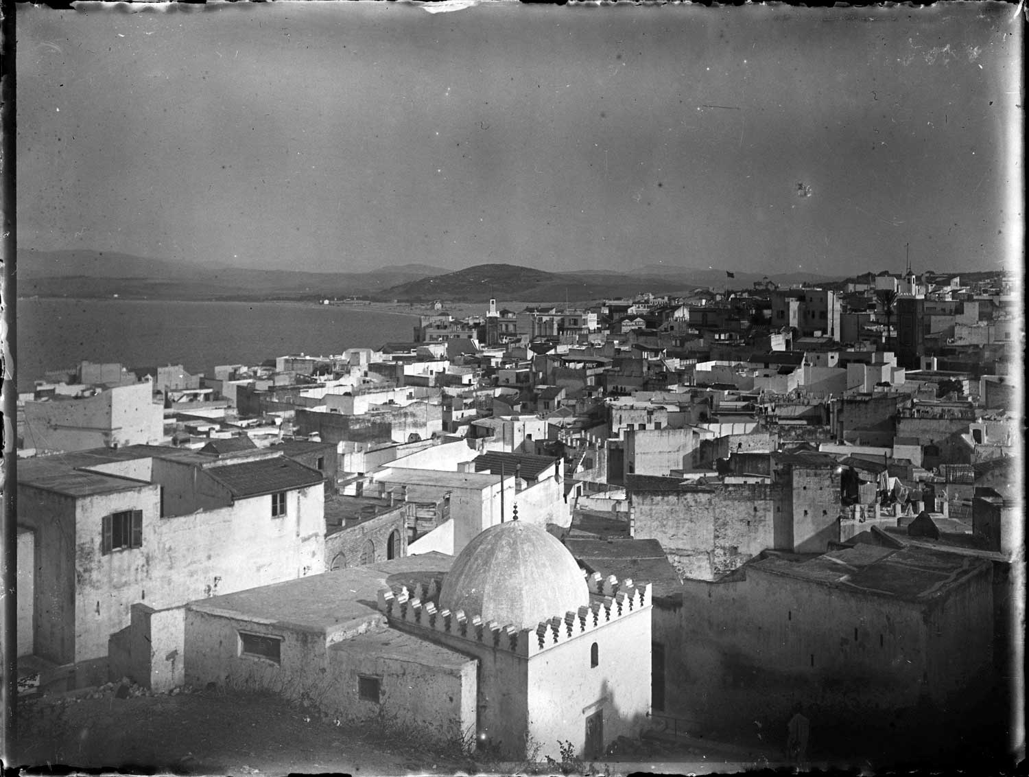Zawiyya Sidi Ben Raïsul - <p>View to the east from above Zawiyya Sidi Ben Raïsul (the dome in the foreground), toward the east. The minarets of Jami' al-Kabir (left, toward the back of the image) and Jami' al-Jadid on the right. Beyond the medina is the beach and Malabata.</p>