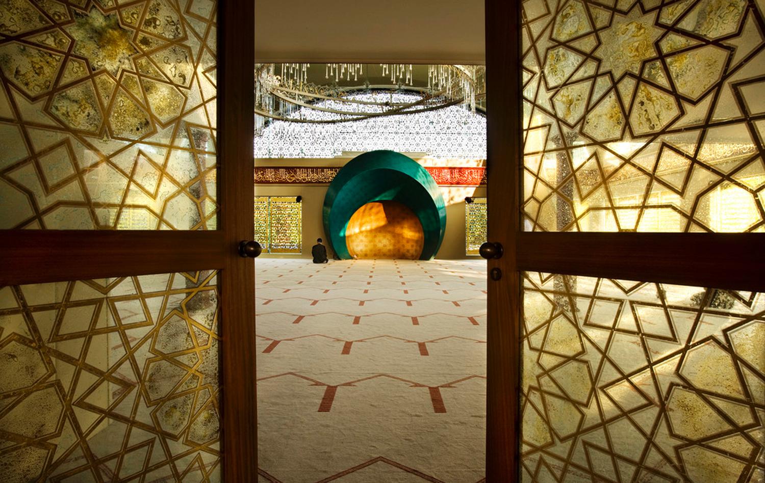 View of the entrance of interior of the mosque and door applications in islamic motifs behind glass