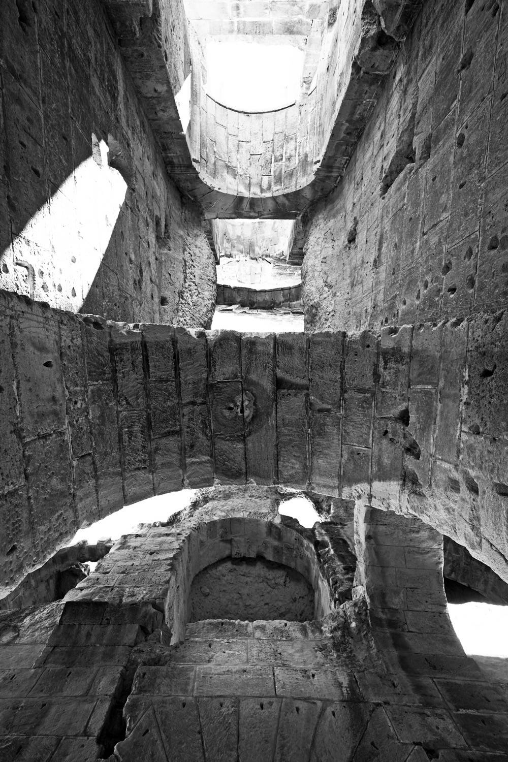 View looking up of arcades, walls, and arches. 