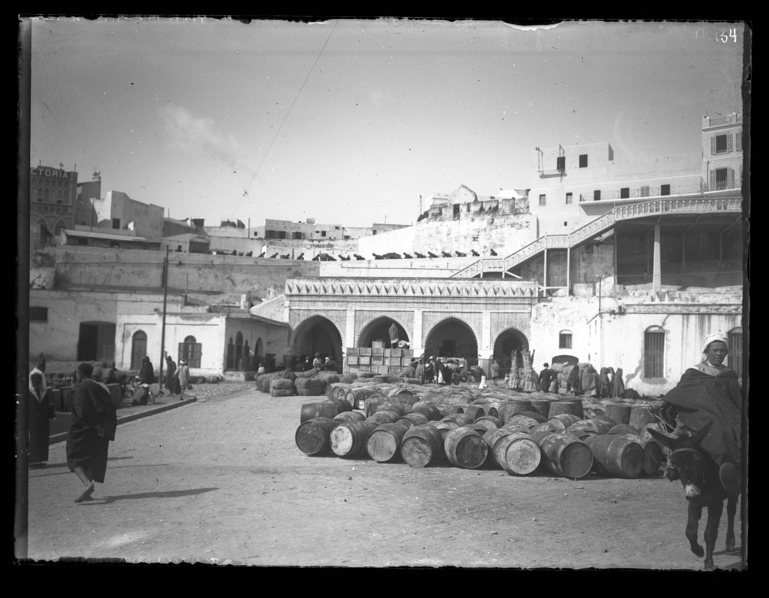 A pile of barrels lined up in front of the Customs House.  Hotel Continental in the background