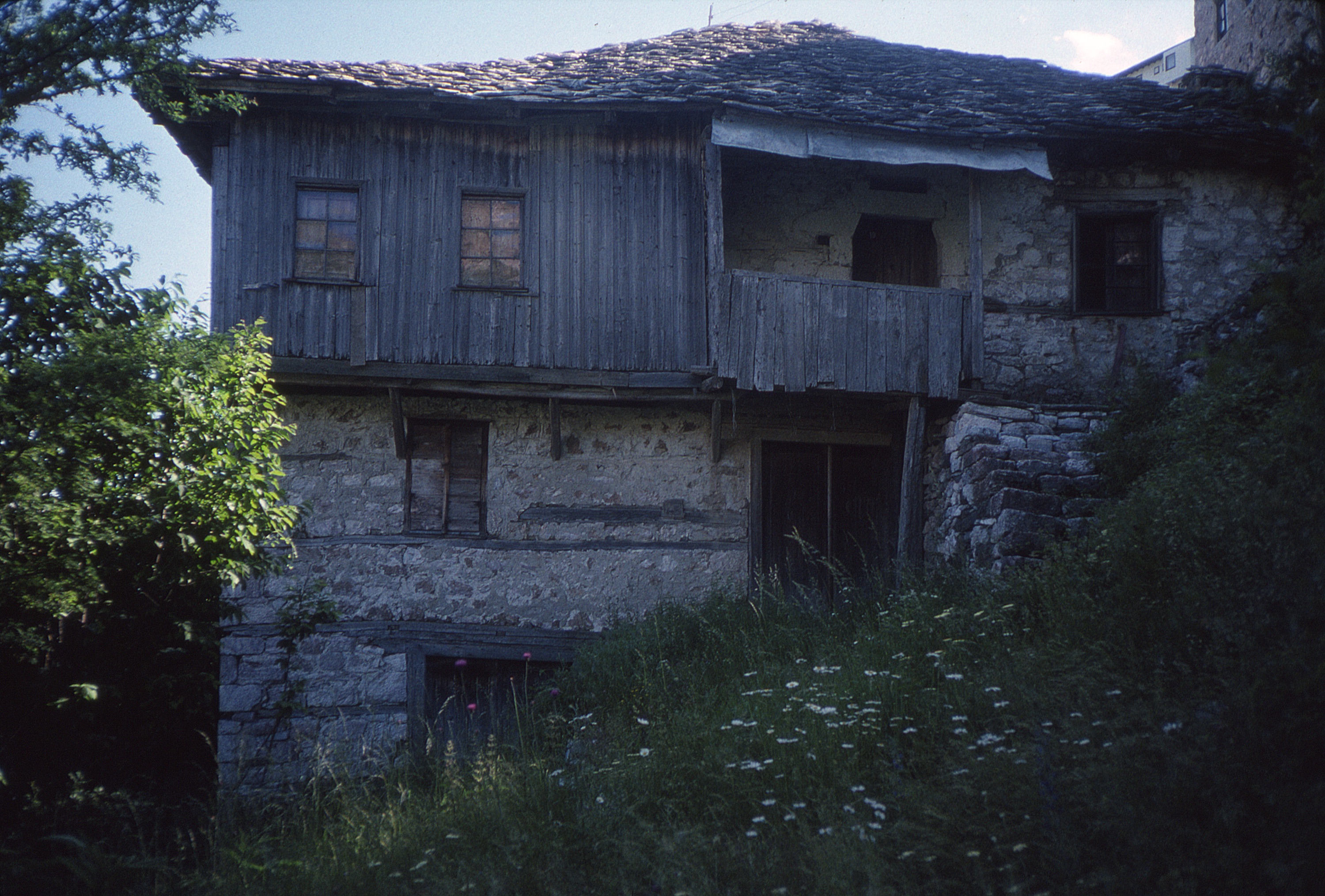 <p>This dwelling shows the shifting of stones and vulnerability of these structures in these highlands. It has the basic three levels with exterior access for each level. The window and door openings have wooden lintels except at the uppermost level where dressed stones form the opening for the entry door.</p>