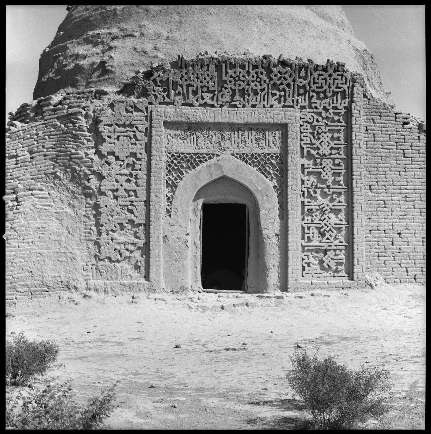 Exterior view from south showing arched doorway with Kufic inscription above.