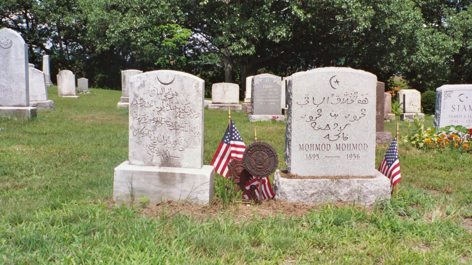 <p>View of the tombstones of Arab-American veterans marked with flags and military insignia</p>
