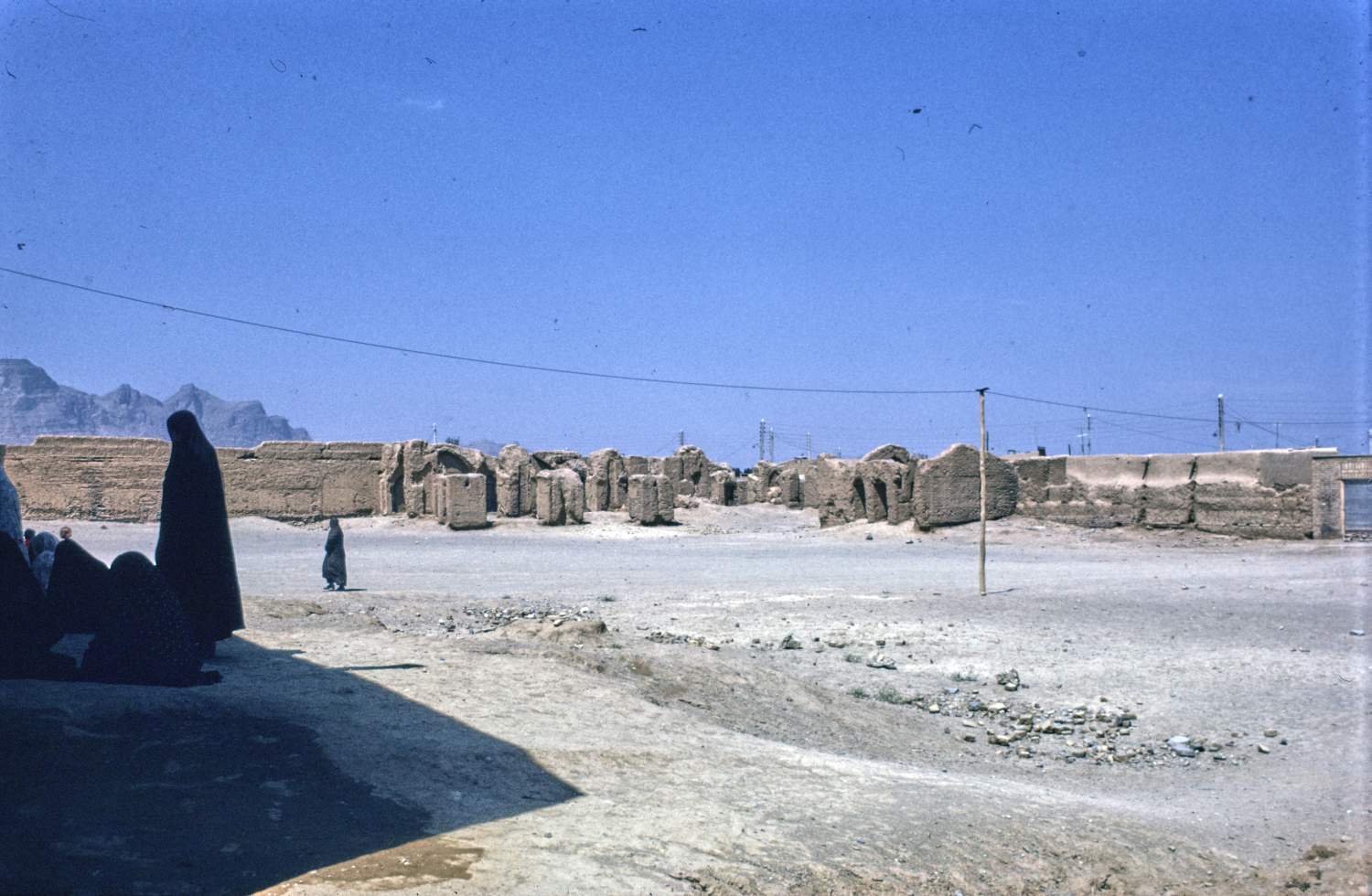 General view of site toward western corner with remains of pillars. Women in foreground.