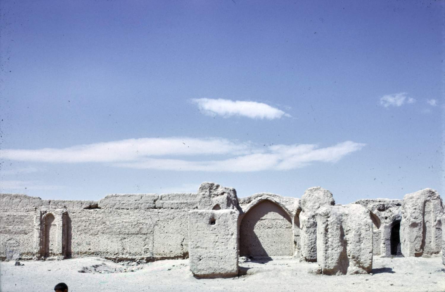 View toward southwestern retaining wall (qibla wall) showing brick masonry of second building phase and remnants of pillars in foreground.