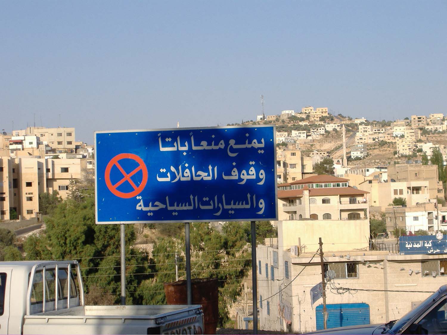  Jerash - View of a sign prohibiting the parking of tour buses, with housing behind